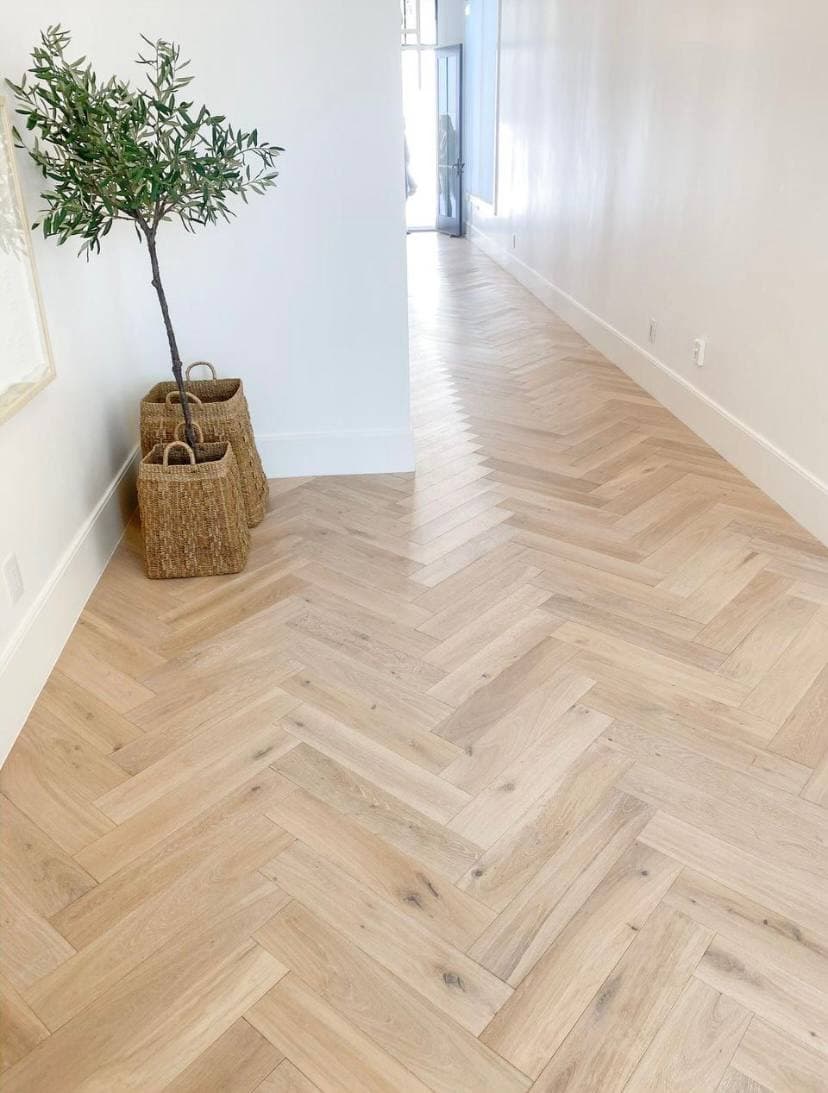 Светлая инженерная доска елкой в длинной проходной зоне