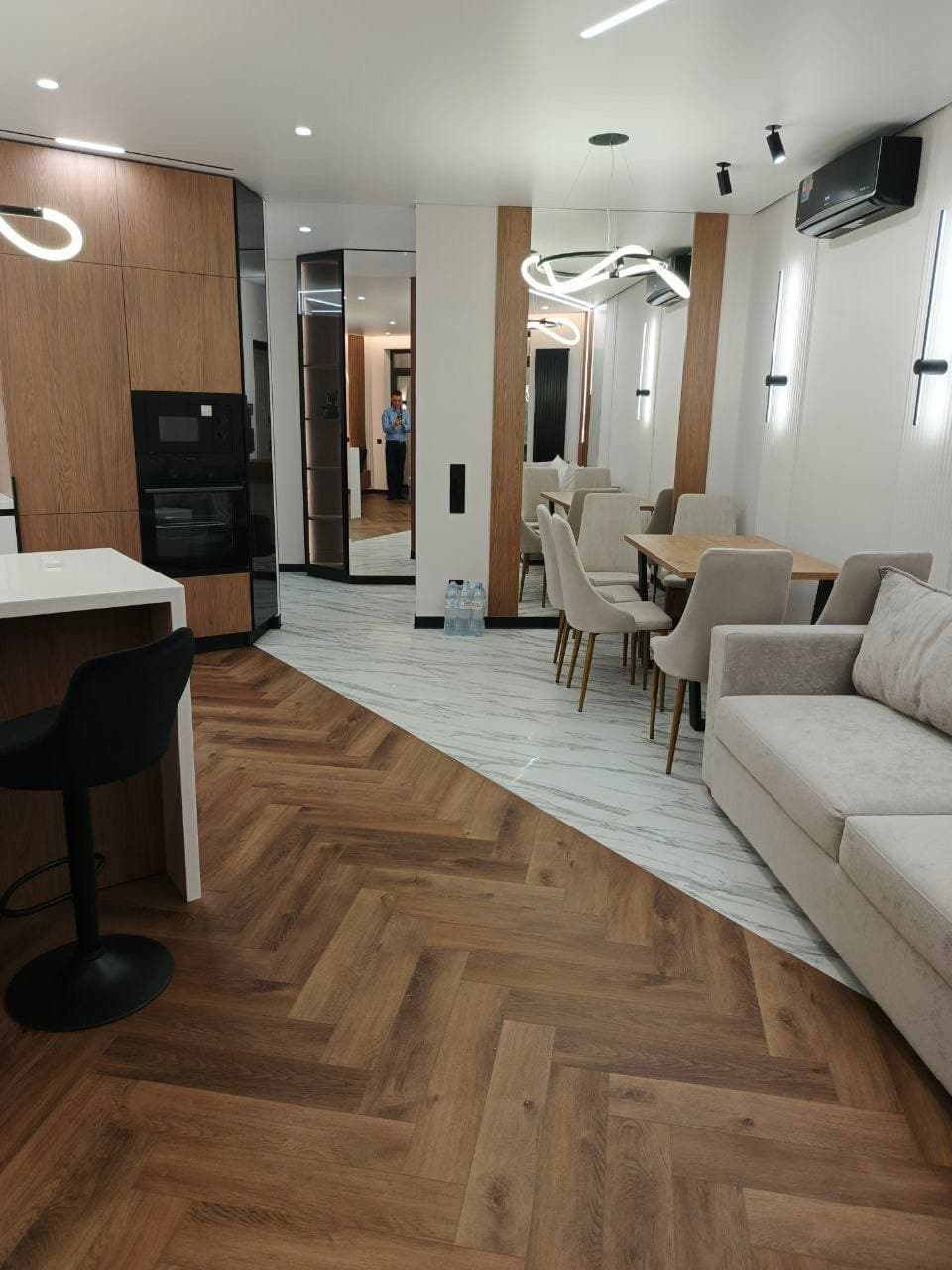 Кухня-гостиная с инженерной доской елкой и переходом к керамограниту