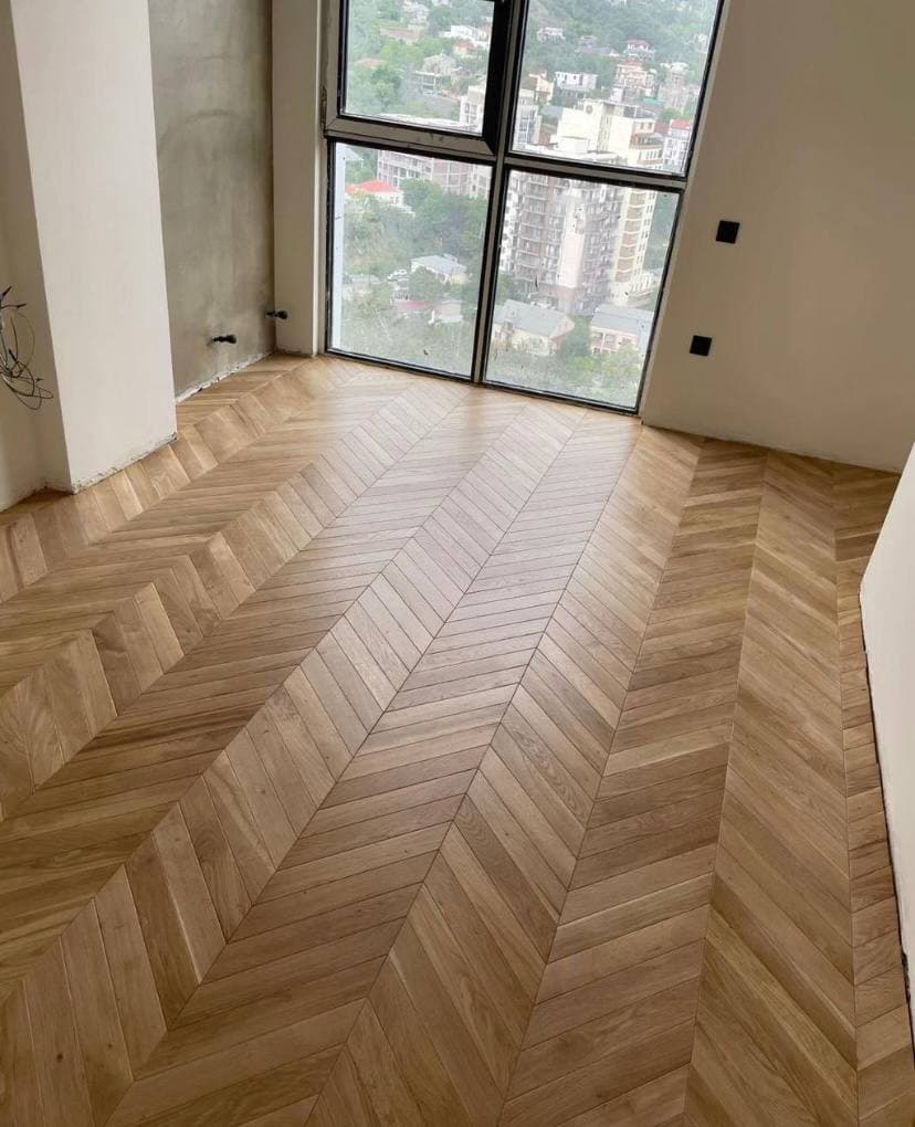 Светлая инженерная доска елкой у панорамного окна